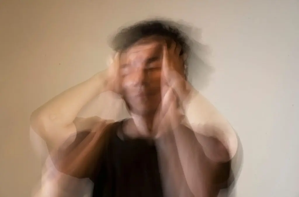 A blurred image of a distressed person holding their head, symbolising confusion and emotional struggle.